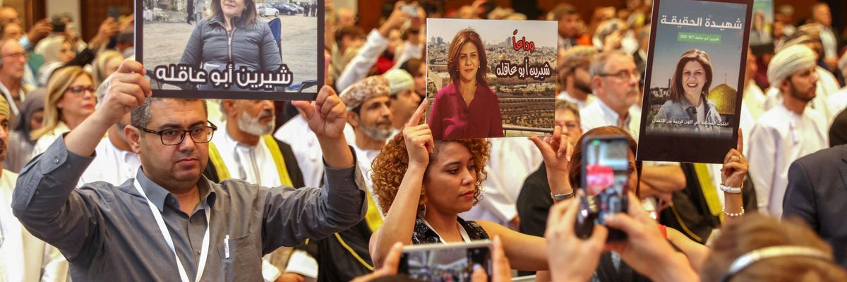 Journalists hold posters displaying Shireen Abu Akleh