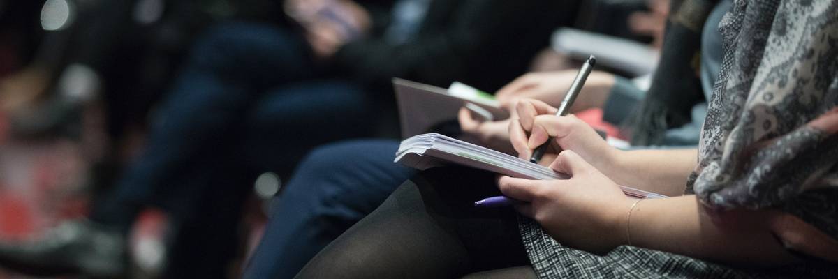 Journalists writing in notebooks