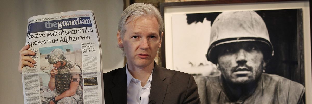 Julian Assange of the WikiLeaks website holds up a copy of The Guardian newspaper 