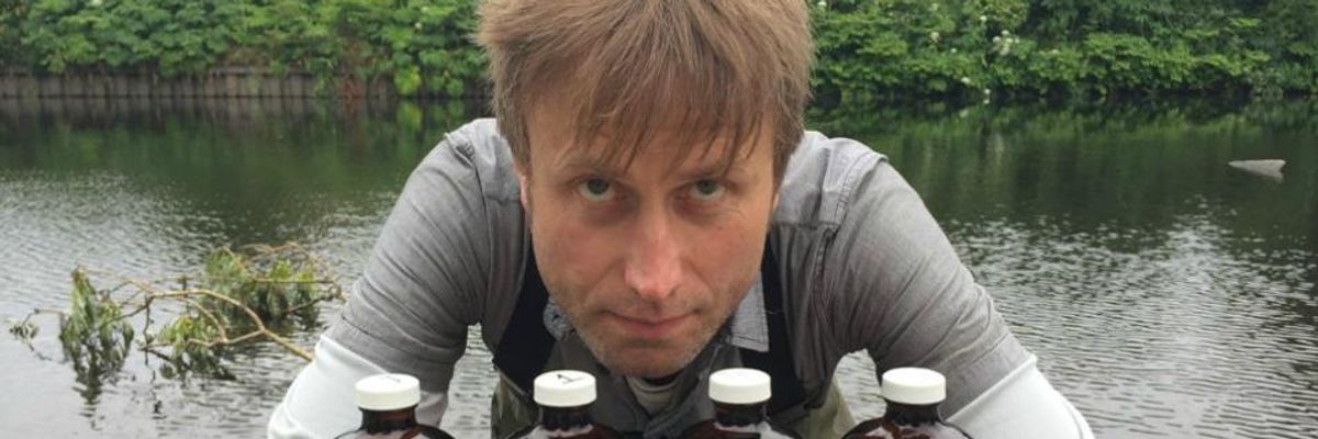 Julian Kirby, a researcher and plastics campaigner at Friends of the Earth, poses with bottles containing water samples from with River Irwell in the United Kingdom