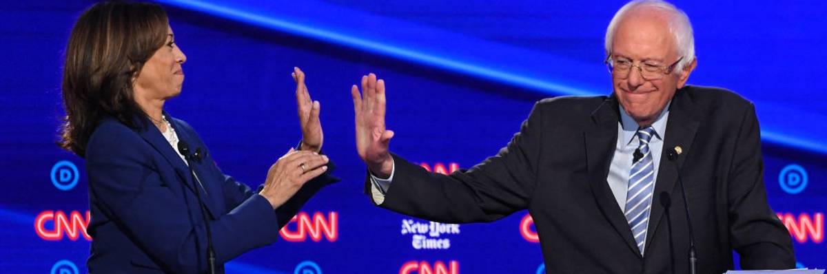 Kamala Harris and Bernie Sanders high-five during a 2019 Democratic presidential primary debate.