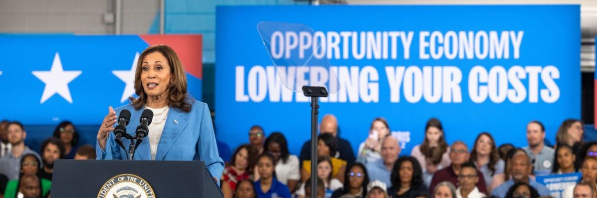 Kamala Harris and sign says "Lowering Your Costs"