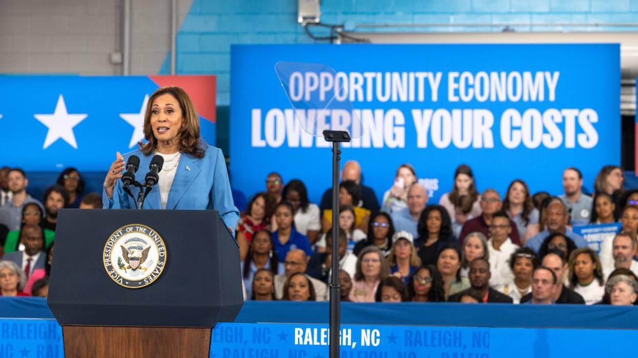 Kamala Harris and sign says "Lowering Your Costs"