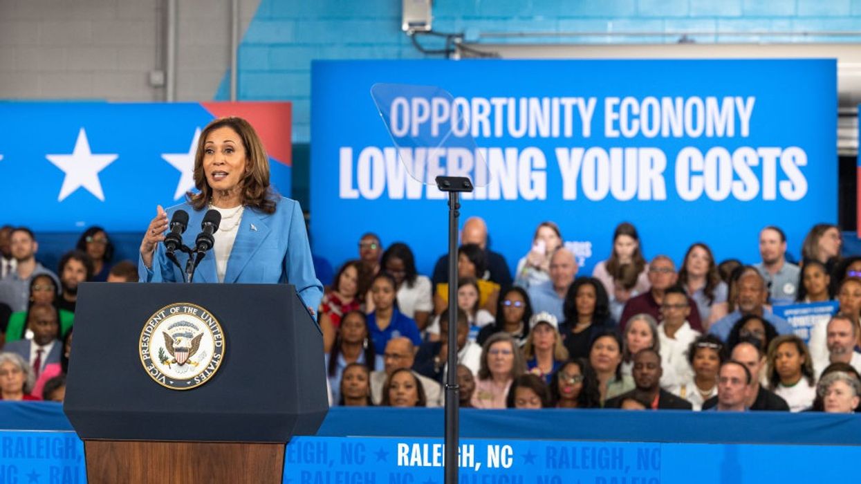 Kamala Harris and sign says "Lowering Your Costs"