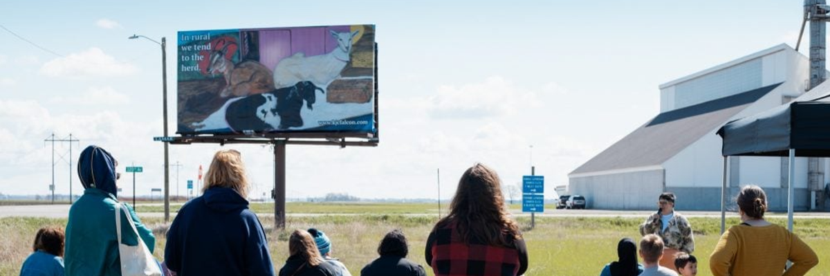 Kandace Creel Falcón gives talk on billboard of goats.