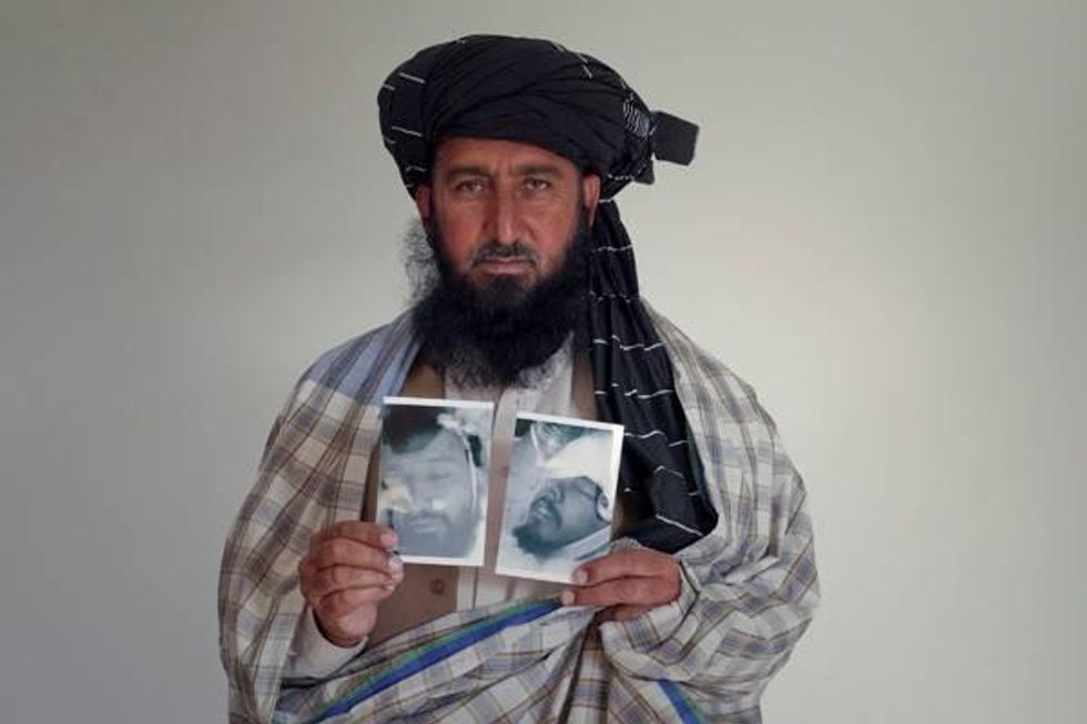 Karim Khan holds pictures of his son and brother who were killed in a US drone attack on their village in 2009. (Photo: Reprieve)