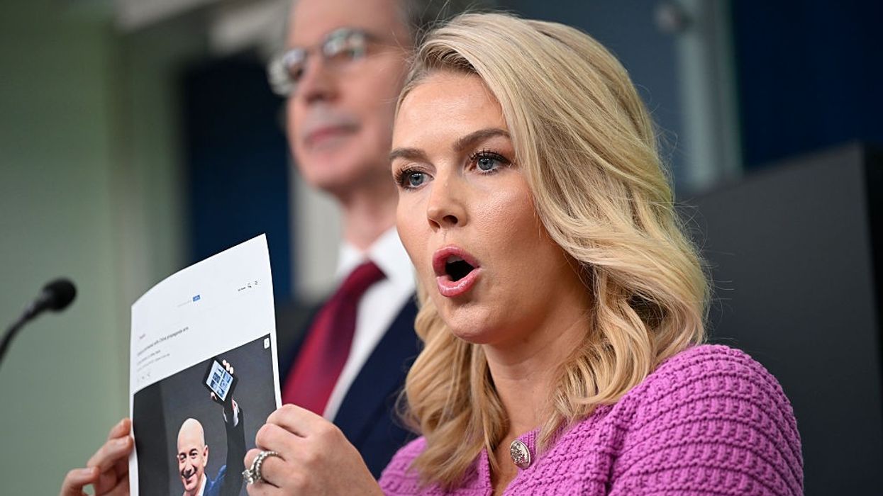 Karoline Leavitt holds a photo of Jeff Bezos