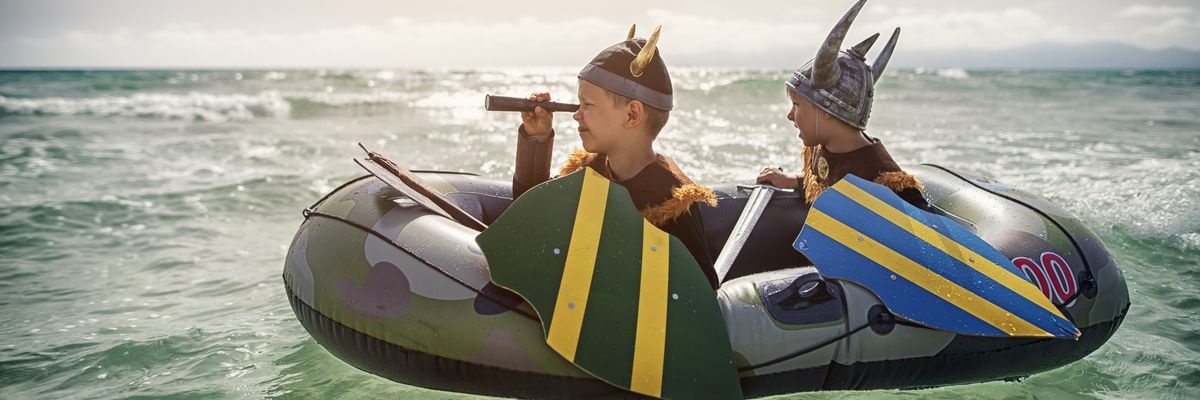 Kids playing vikings at sea on a boat.