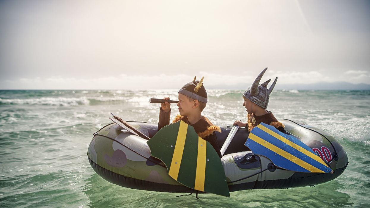 Kids playing vikings at sea on a boat.
