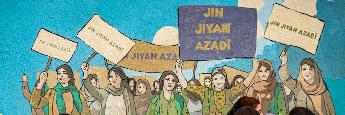 Kurds in Syria holding sign reads “Jin Jiyan Azadi,” which in English means “"Life, Woman, Freedom.”