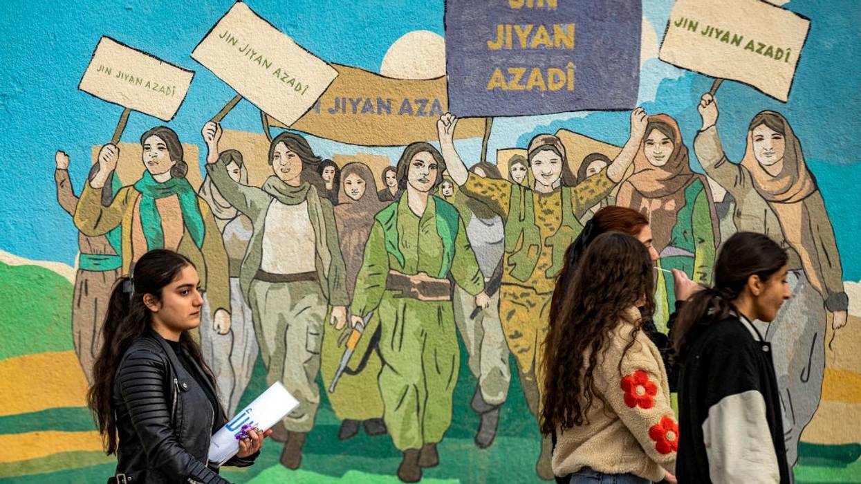 Kurds in Syria holding sign reads “Jin Jiyan Azadi,” which in English means “"Life, Woman, Freedom.”