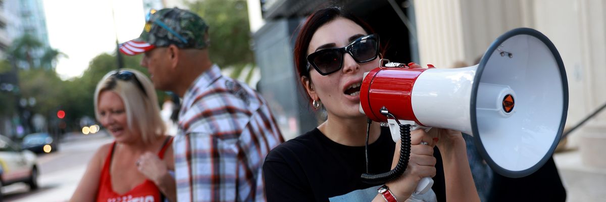Laura Loomer speaks into a megaphone.