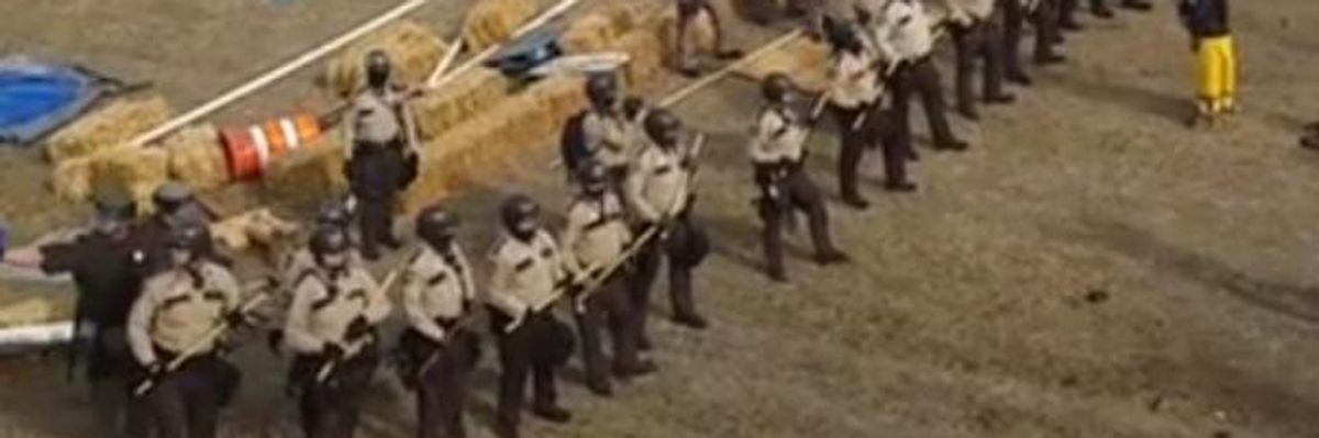 Armed With Riot Gear, Militarized Police Begin Forcibly Clearing DAPL Protest Camp