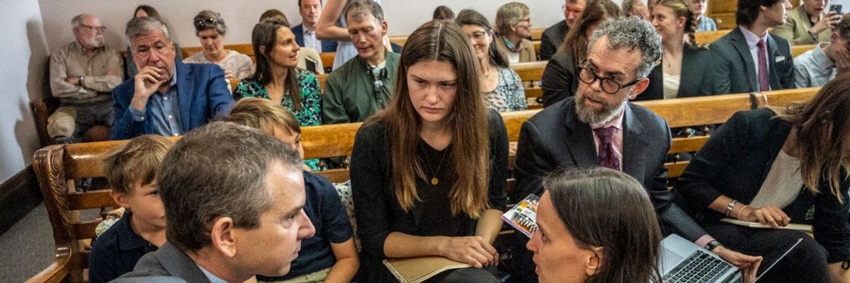 Lead Montana youth plaintiff Rikki Held, 22, confers with members of Our Children's Trust legal team in a courhouse.