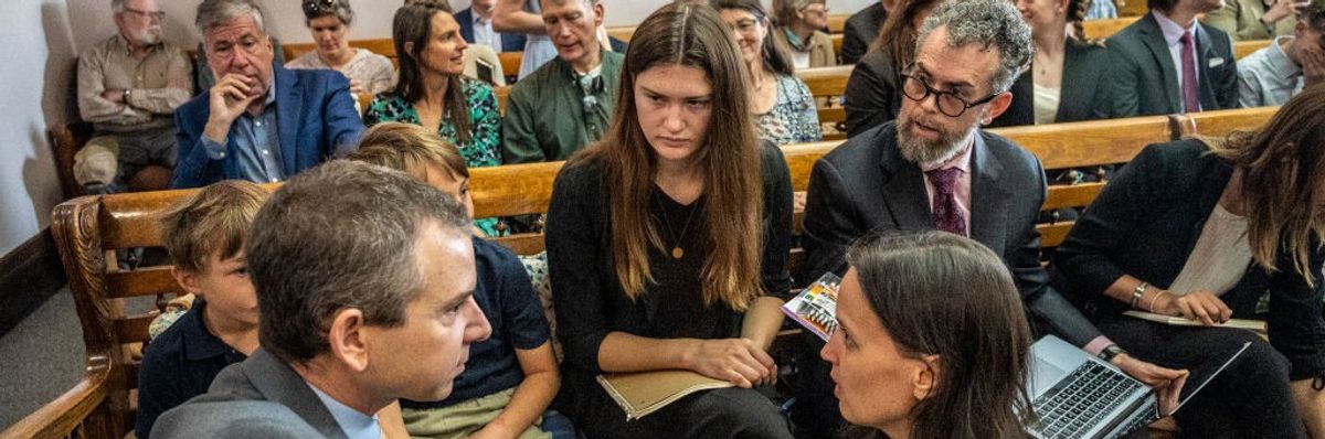 Lead Montana youth plaintiff Rikki Held, 22, confers with members of Our Children's Trust legal team in a courhouse.