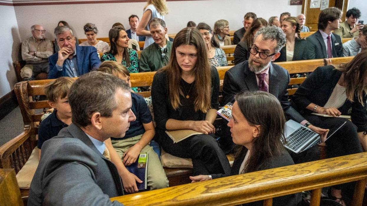 Lead Montana youth plaintiff Rikki Held, 22, confers with members of Our Children's Trust legal team in a courhouse.