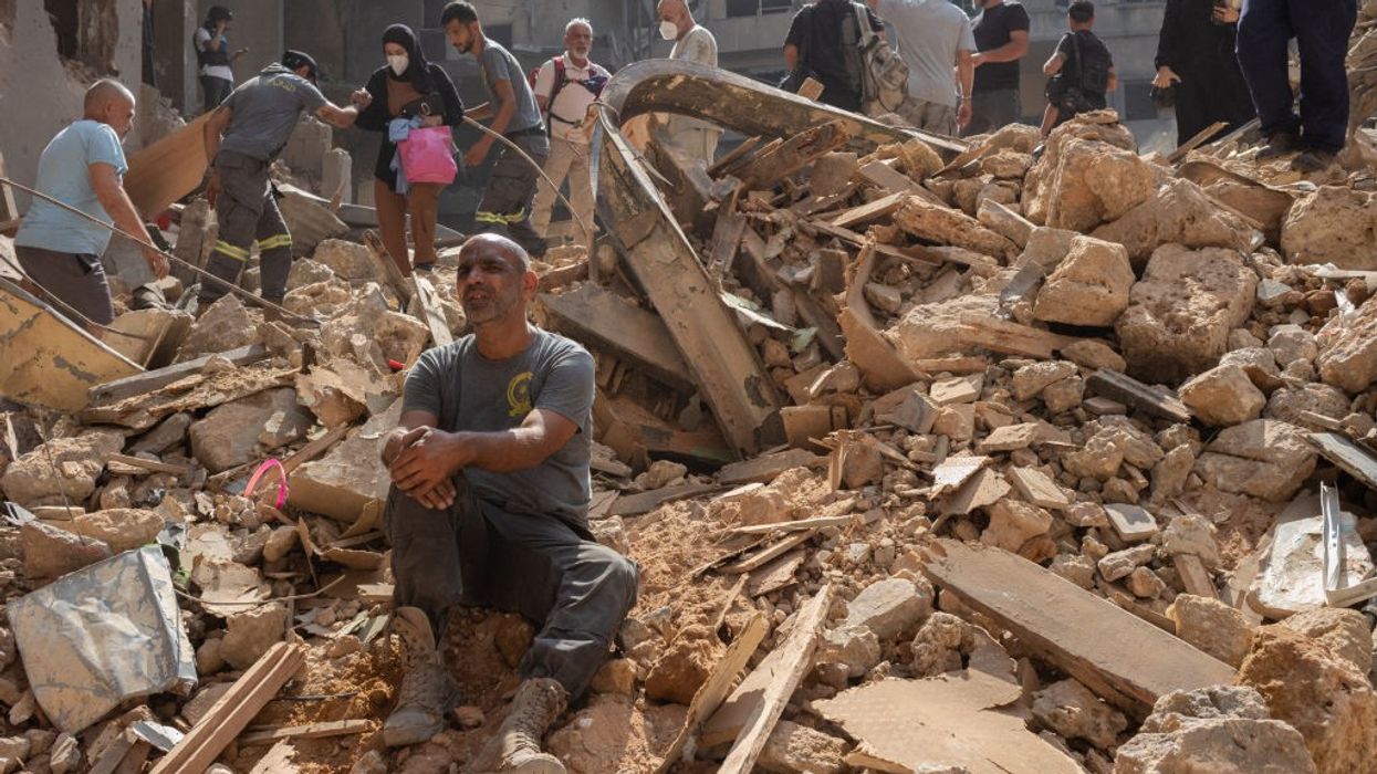 Lebanese are seen among the rubble of an Israeli airstrike in Beirut
