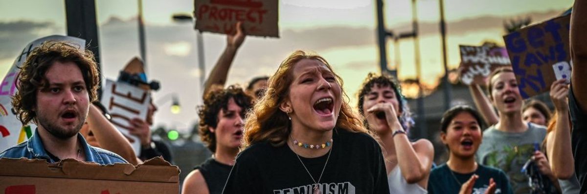 LGBTQ rights supporters protest against Florida Governor Ron Desantis. Signs say "Fuck DeSantis" and "Kill Fascism"