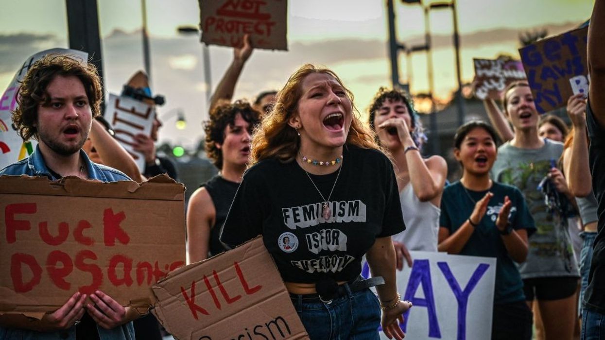 LGBTQ rights supporters protest against Florida Governor Ron Desantis. Signs say "Fuck DeSantis" and "Kill Fascism"
