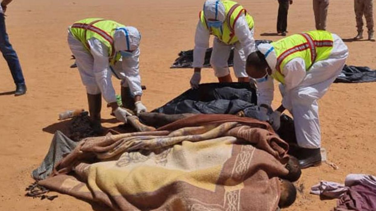 Libyan first aid workers remove bodies of migrants who died in the Sahara