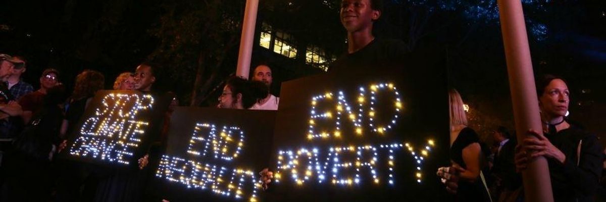Light-up signs reading, 'Stop climate change," "End Inequality," and "End Poverty."