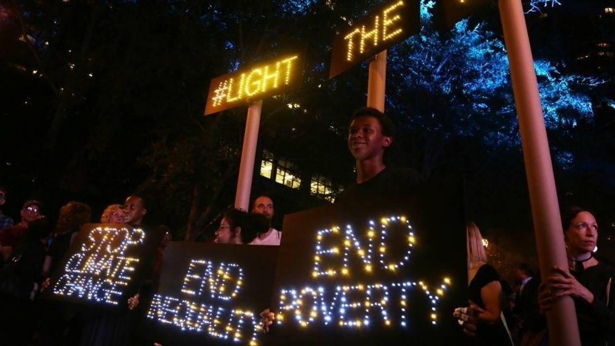 Light-up signs reading, 'Stop climate change," "End Inequality," and "End Poverty."