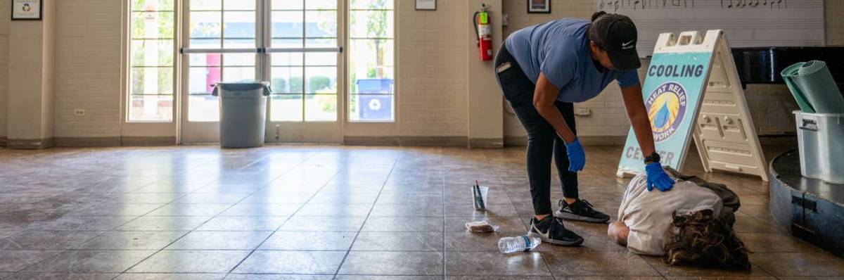 Lisa Long attempts to wake a cooling center resident