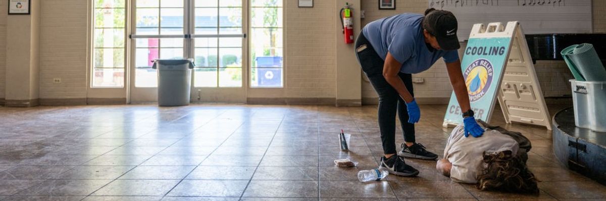 Lisa Long attempts to wake a cooling center resident