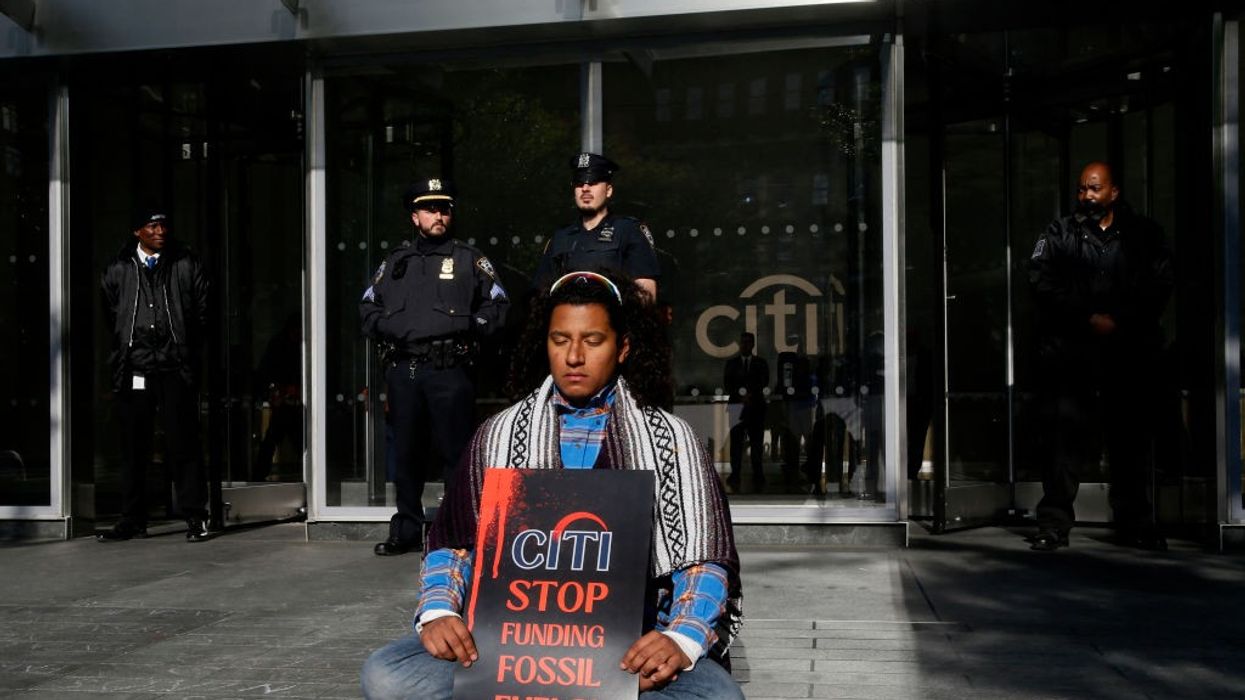 Lone protester holds sign: "Citi: Stop Funding Fossil Fuels"
