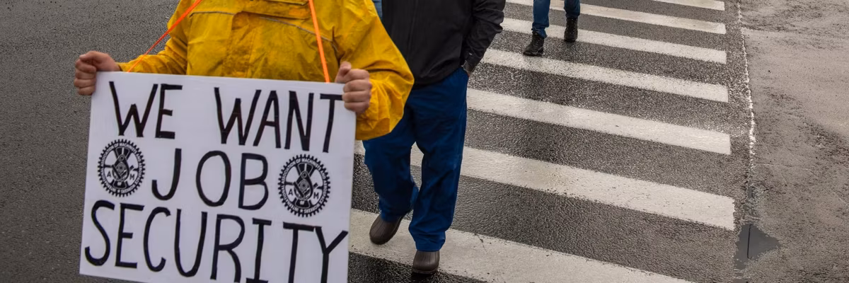 Machinist union workers march with placards expressing their