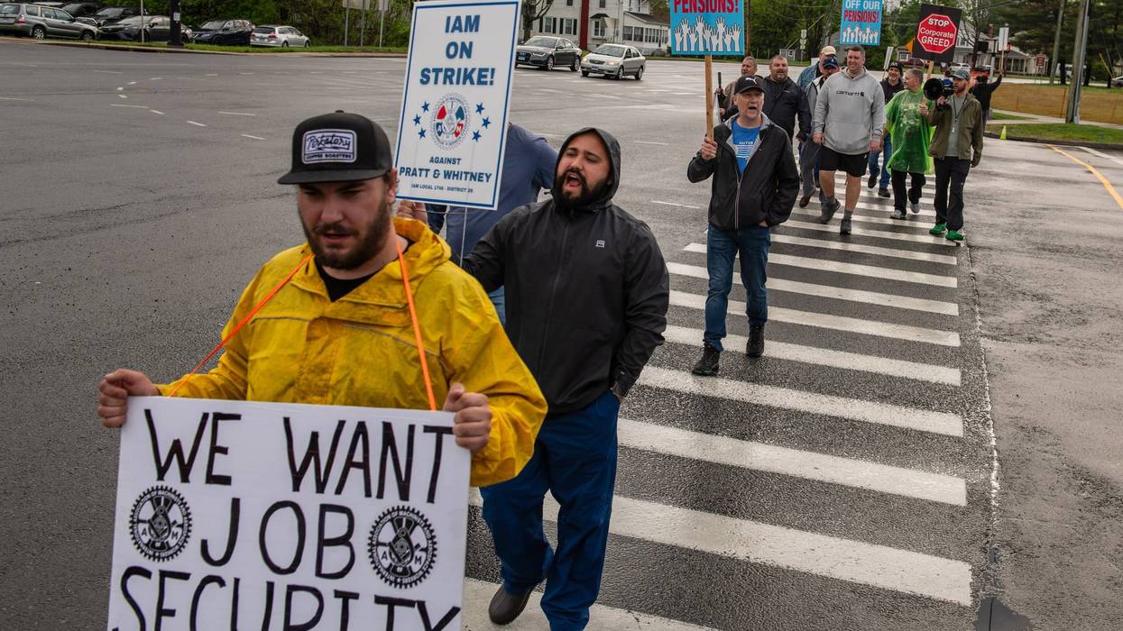 Machinist union workers march with placards expressing their