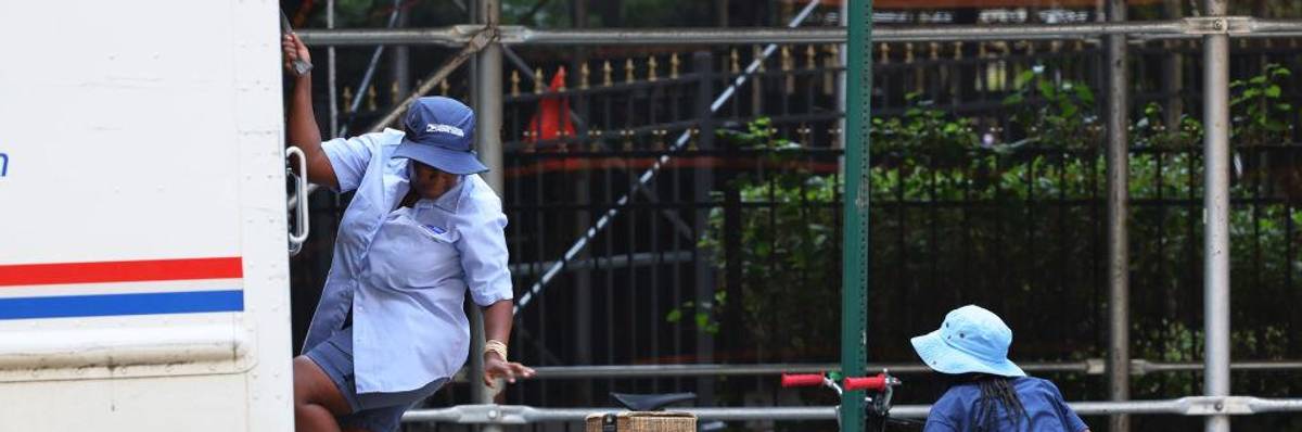 Mail delivery workers unload a truck on Flatbush Avenue on July 22, 2022 in the Flatbush neighborhood of the Brooklyn borough in New York City.
