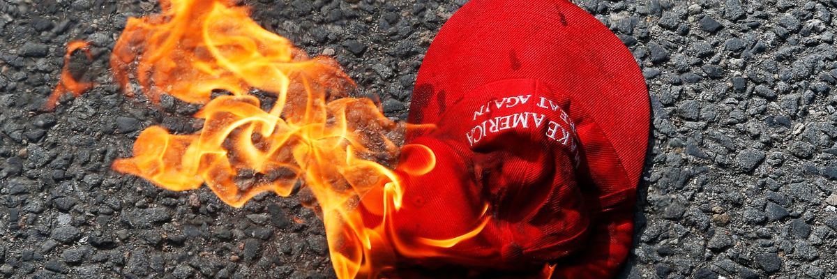 Make America Great Again hat burns on the ground after a protest by Boston's far-right group Super Happy Fun America. 