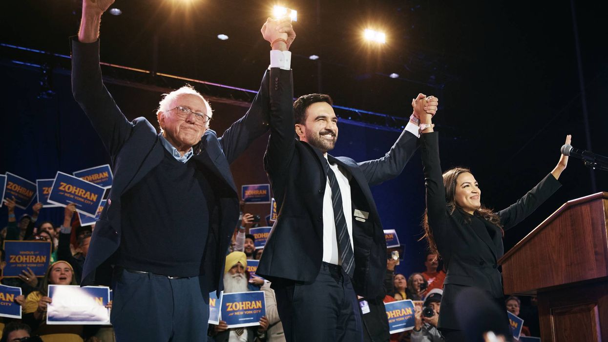 Mamdani holds hands up high with Bernie Sanders on one side and AOC on the other