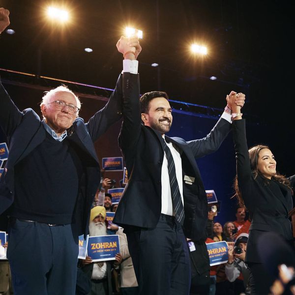 Mamdani holds hands up high with Bernie Sanders on one side and AOC on the other