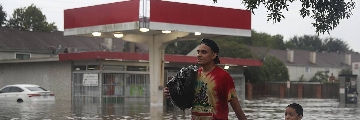 Man and child walking through flooding street