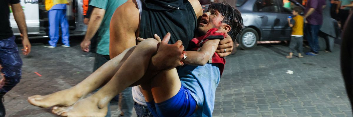 man carries a child, wounded by Israeli airstrikes