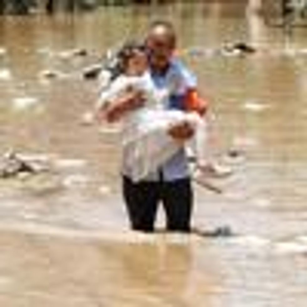 Man carries child through flooded waters