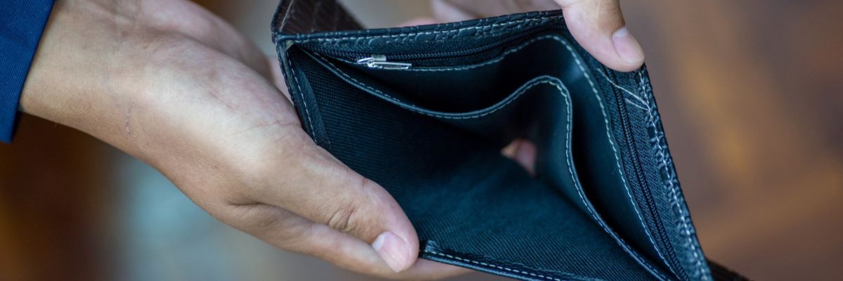 Man holding and showing an empty wallet (no money)