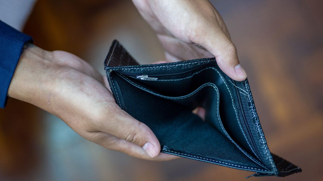 Man holding and showing an empty wallet (no money)