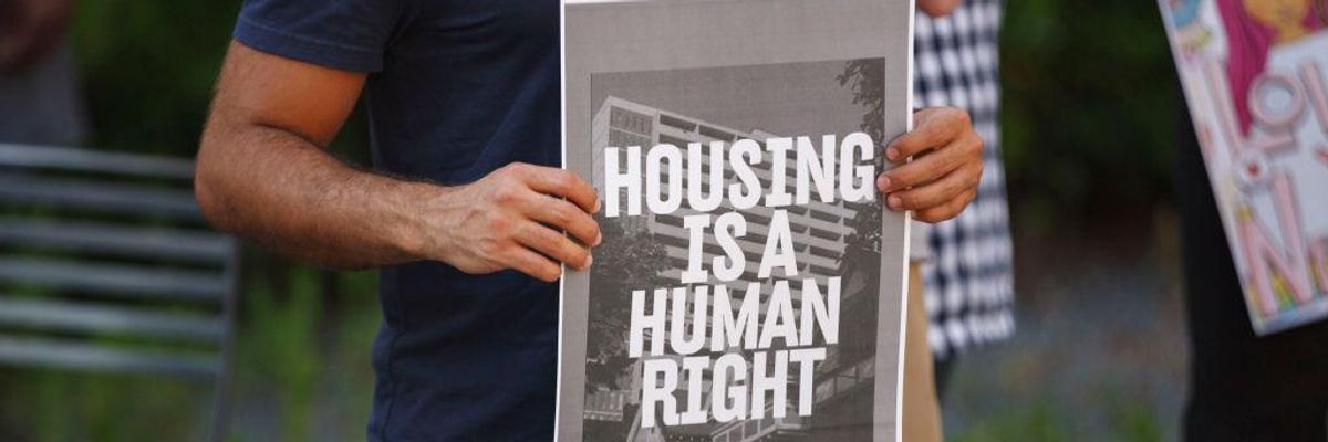 Man holds a placard during a rally for housing rights