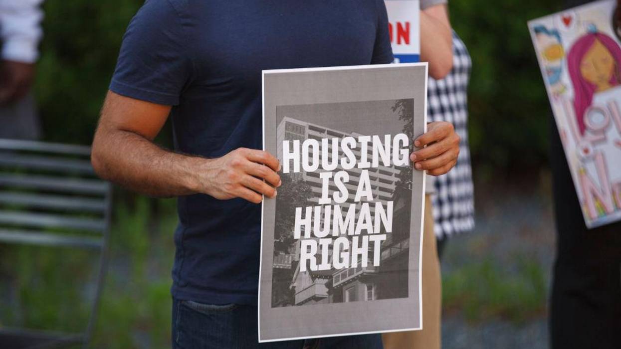 Man holds a placard during a rally for housing rights