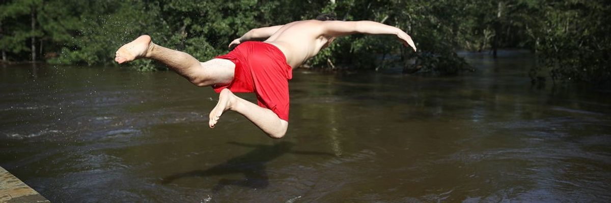 man jumps into creek