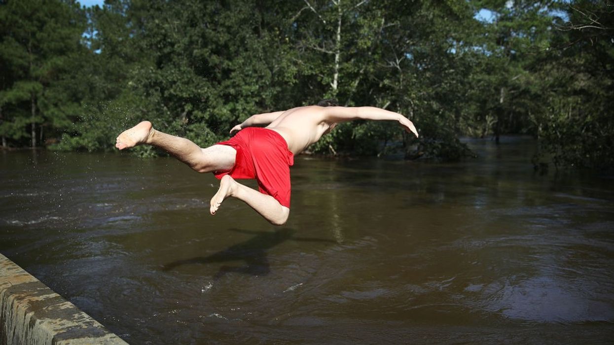 man jumps into creek