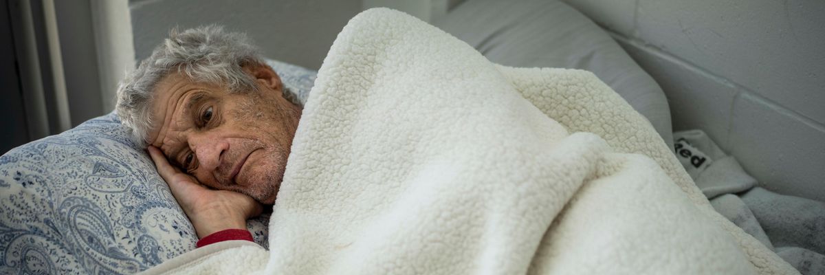 Man recovers on a bed at a shelter after losing home to Hurricane Ian in Florida
