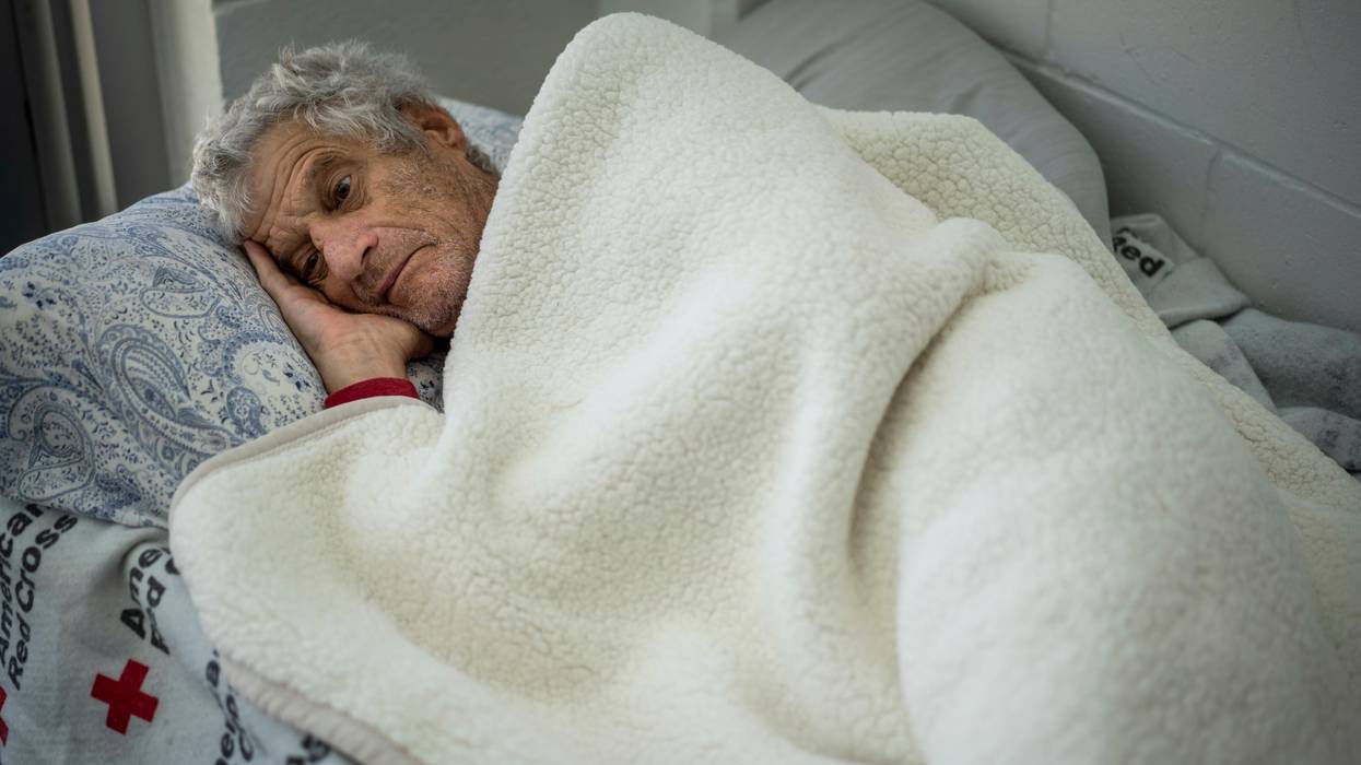 Man recovers on a bed at a shelter after losing home to Hurricane Ian in Florida