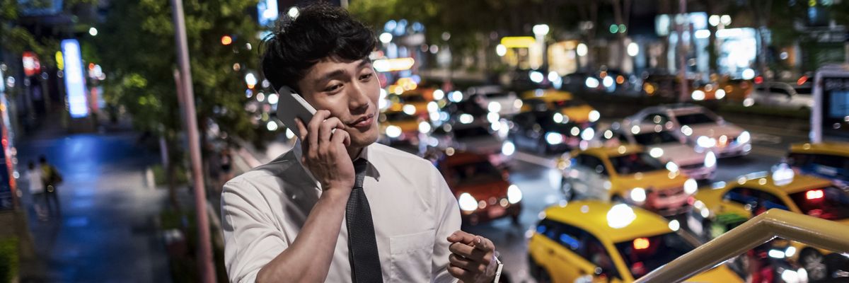 man using phone on the footbridge at night