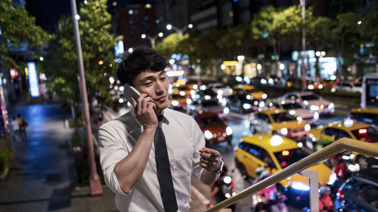 man using phone on the footbridge at night