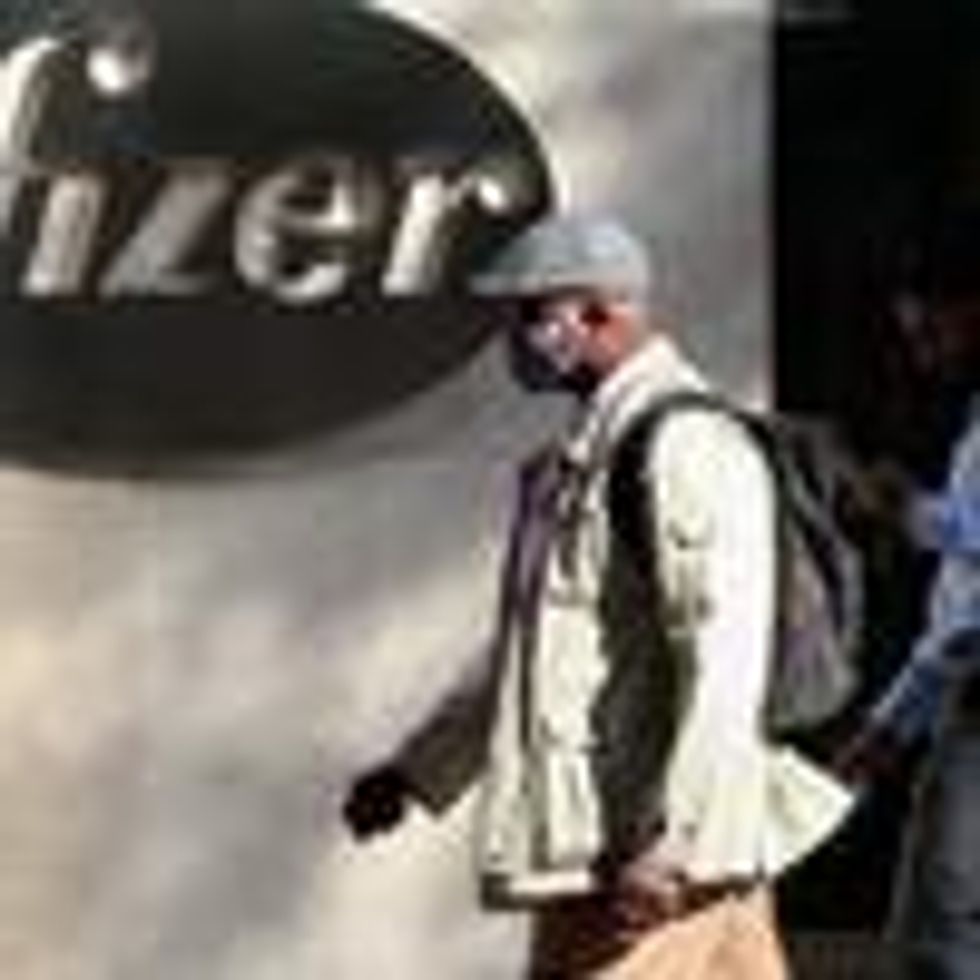 Man walks past Pfizer logo