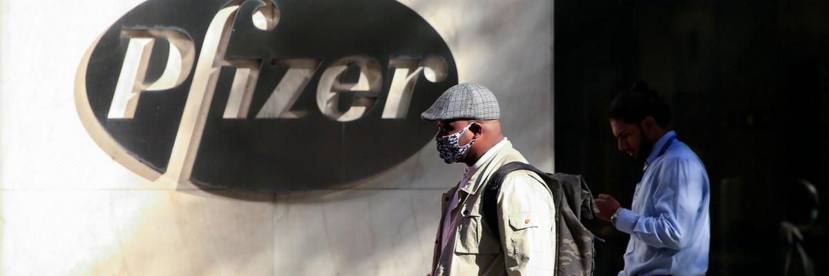 Man walks past Pfizer logo